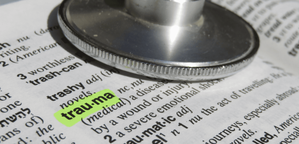 Trauma word highlighted with a stethoscope on top of dictionary