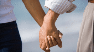Close-up of a couple walking hand in hand.