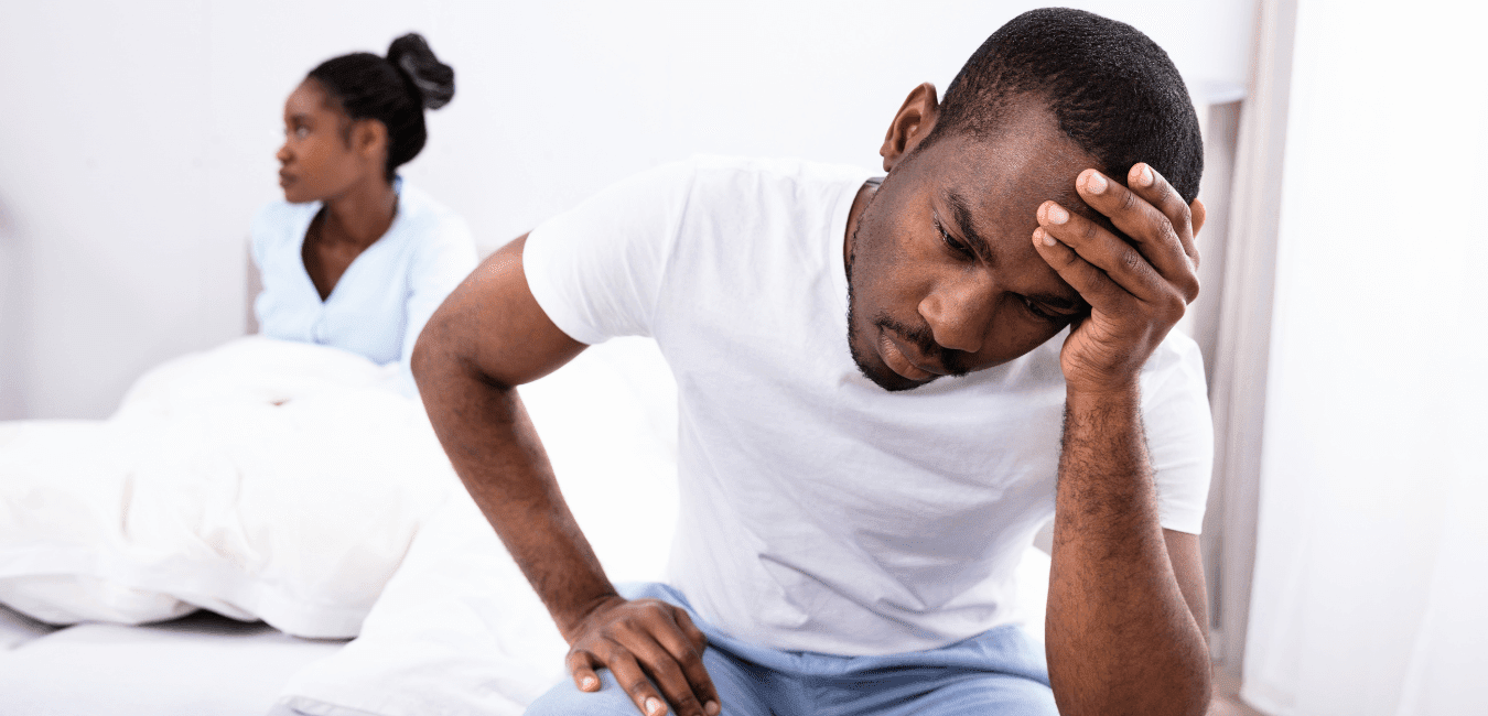African couple wearing shirt looking unhappy on their bed
