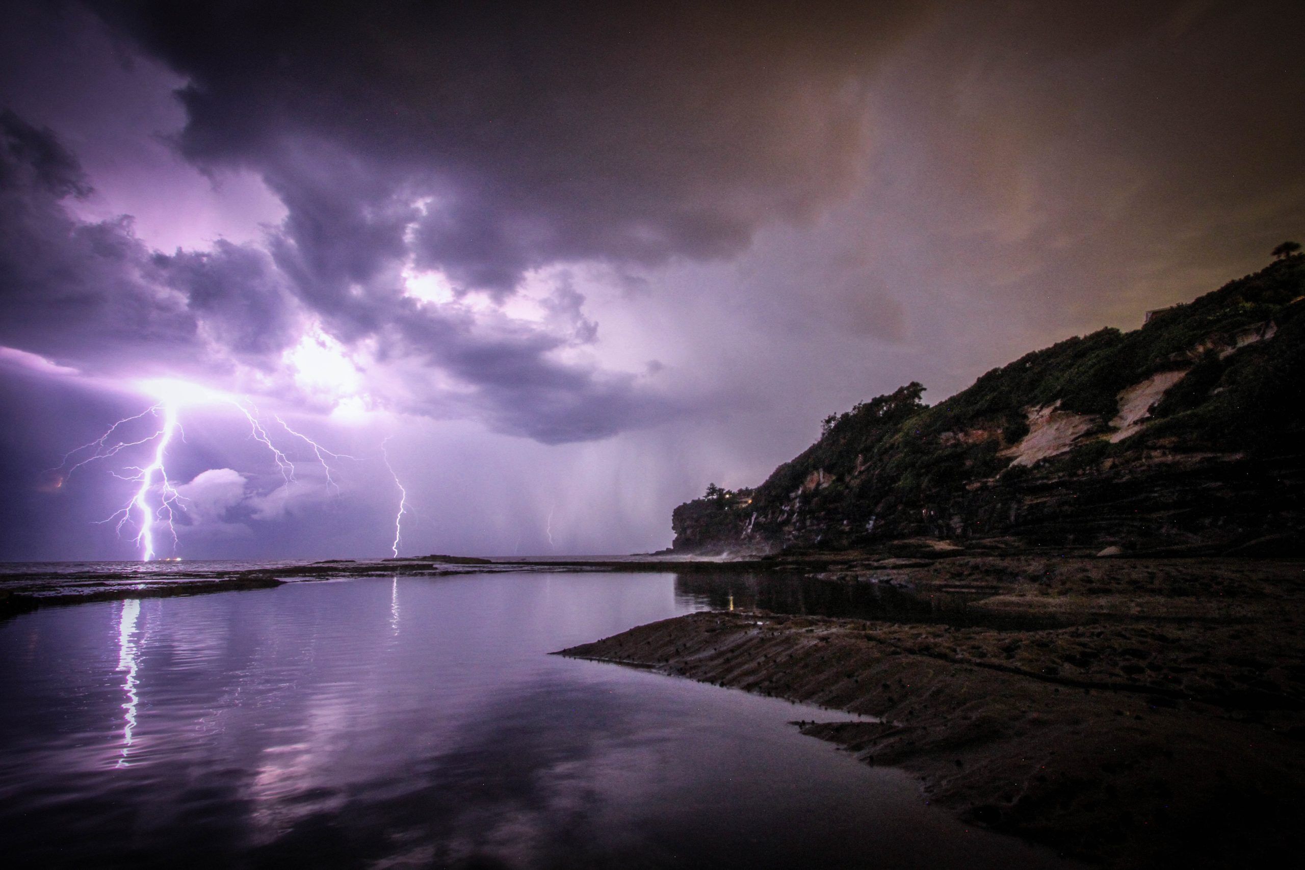 lightening strikes overtop a body of water