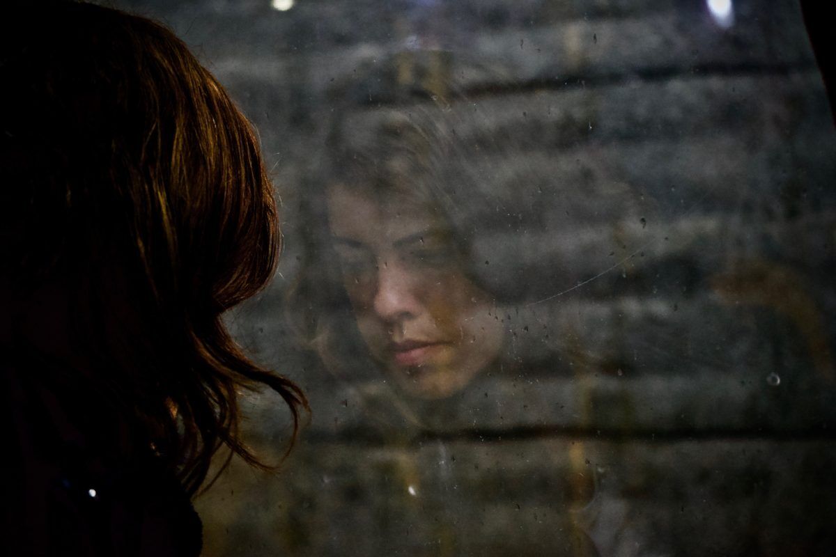 woman looking out a rainy window