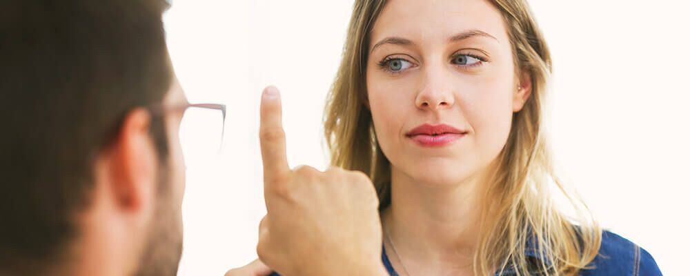 A counselor with pale skin and his index finger pointed up moves through his patients field of vision with his finger.