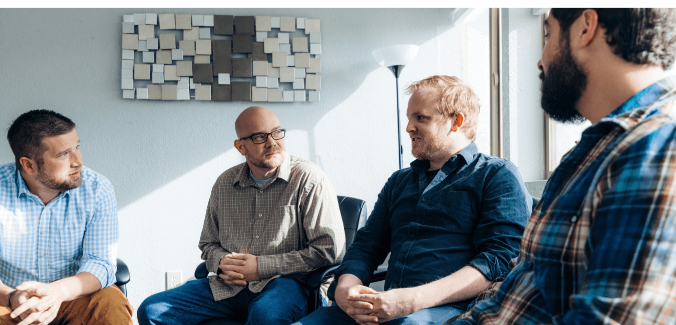 Man talking in group therapy in a center sharing experiences, showing encouragement, and test