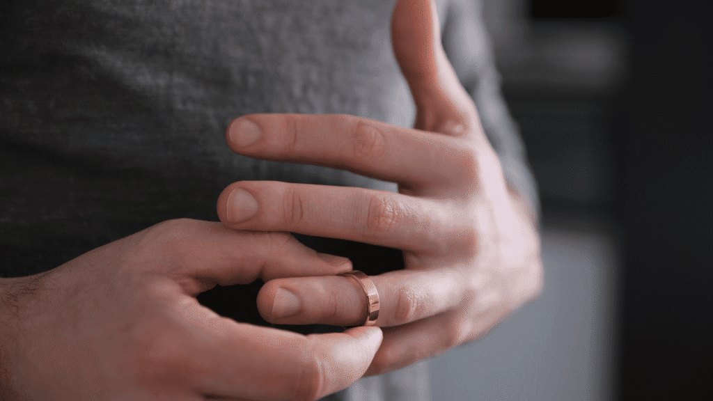 Close-up of a man's hand removing a wedding ring