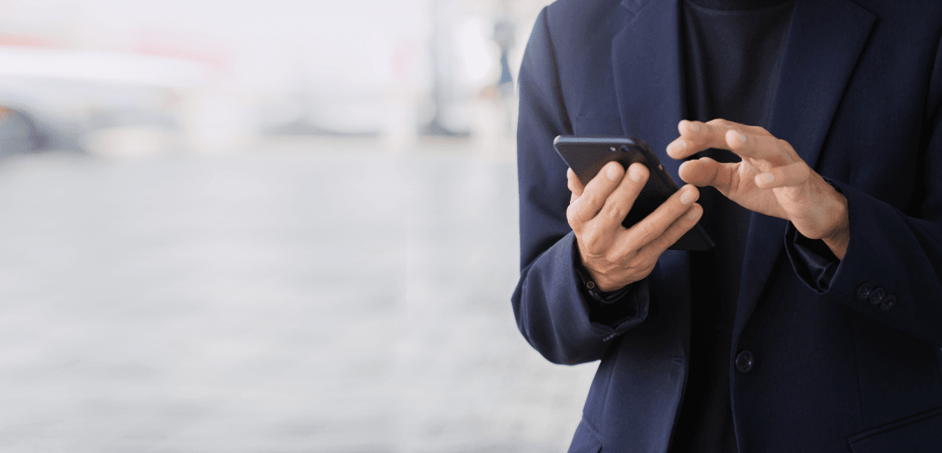 Focus shot of man wearing suit using mobile phone at public place