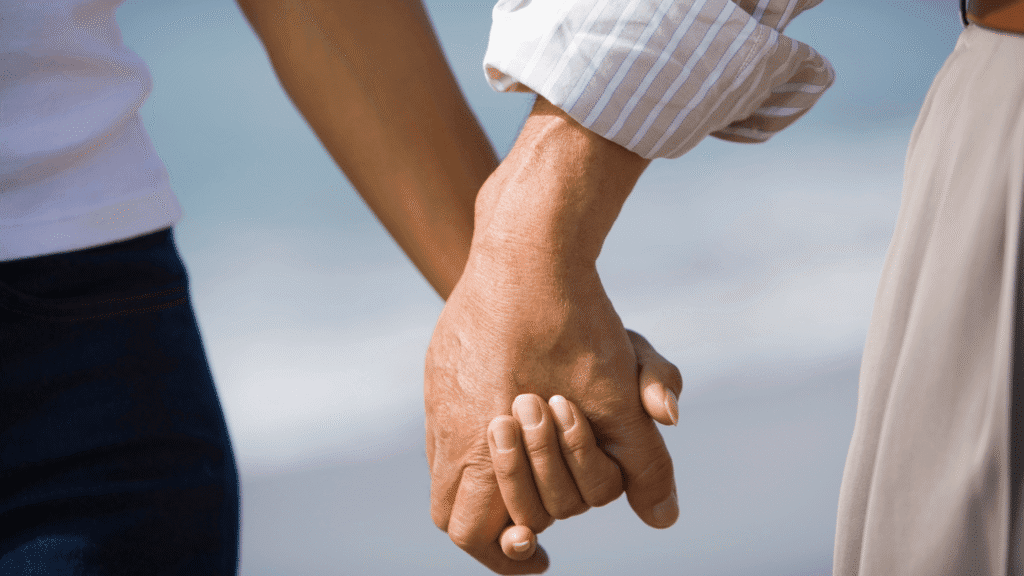 Close-up of a couple walking hand in hand.