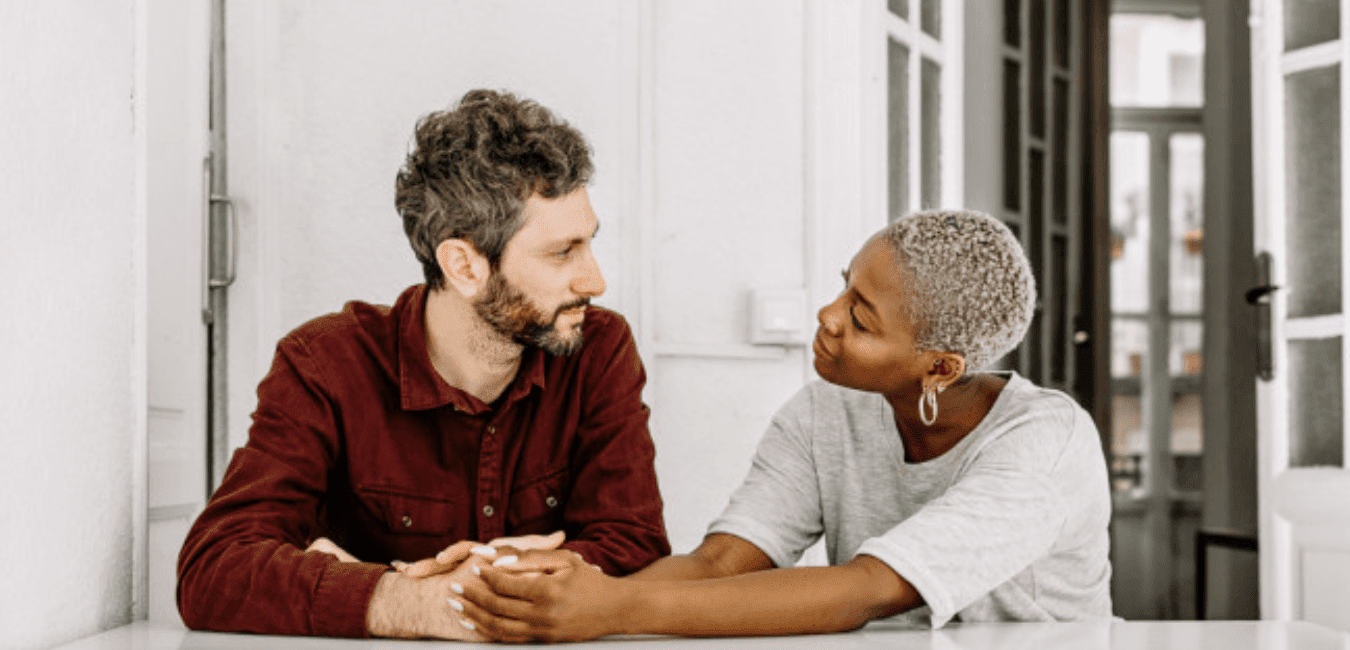 Couple sitting having conversation comforting each other at home