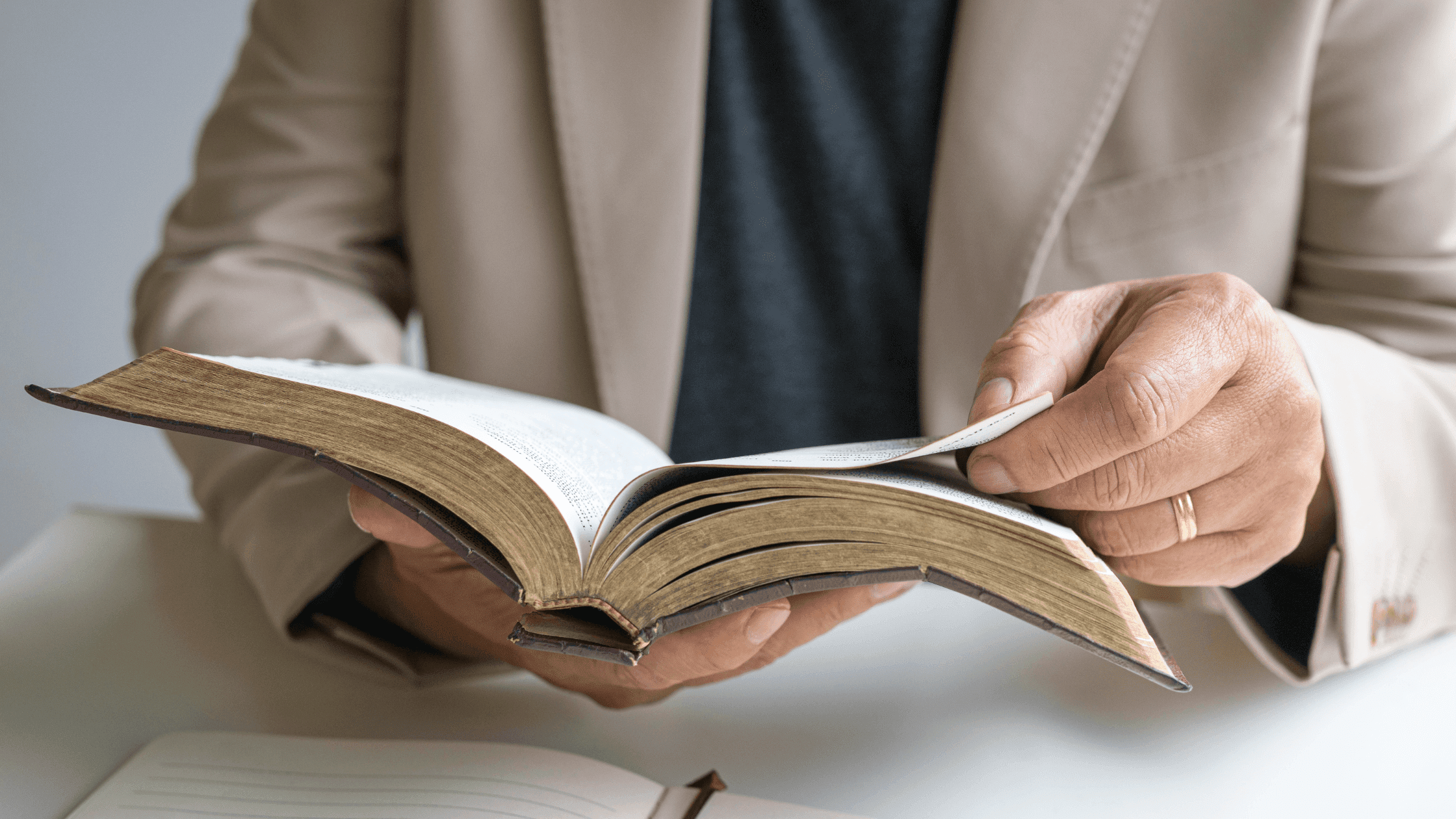 Focus shot of a person sitting down with the Bible open.