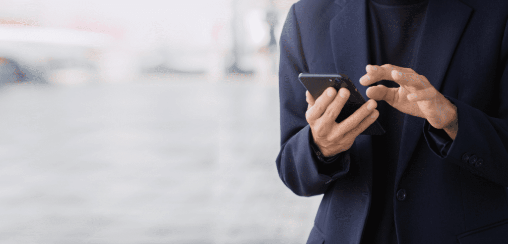 Focus shot of man wearing suit using mobile phone at public place