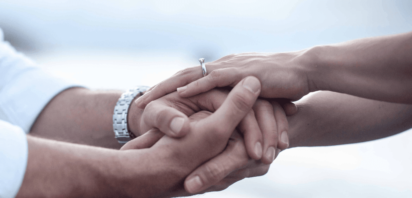 two people are holding hands. The joined hands are the center of the photo. Only hands and forearms are showing