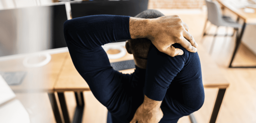 Hairy man wearing blue sweater stretching getting ready for change in front of computer