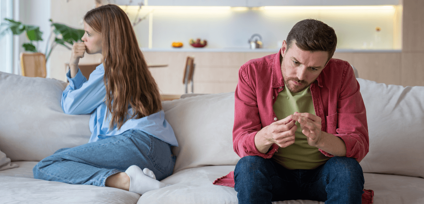 Couple sitting on couch at home not talking looking like having a problem