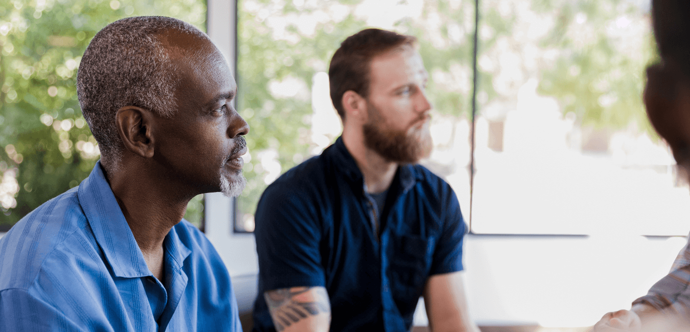 Group of man looking away in addiction community retreat
